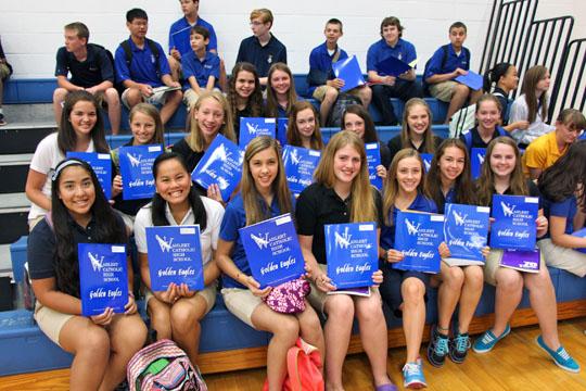 The freshmen show off their blue folders they were given on the first day.