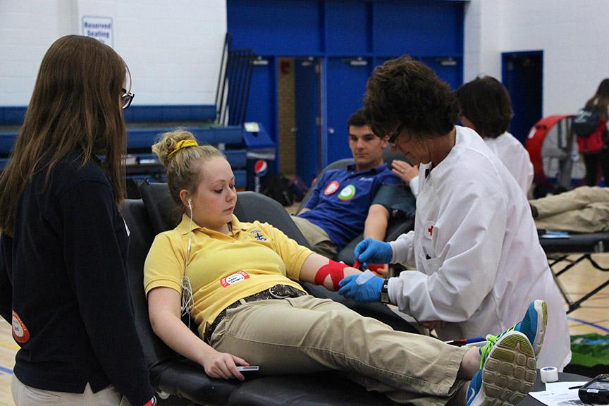 SAVING+LIVES+Music+helps+Maddie+DeMoully+stay+calm+as+she+donates+blood+at+the+blood+drive+held+Nov.+3.+The+drive+yielded+52+usable+pints+of+blood.+Although+Hanna+Doerr+eagerly+tried+to+donate+for+the+first+time+ever%2C+her+results+were+not-so-successful.
