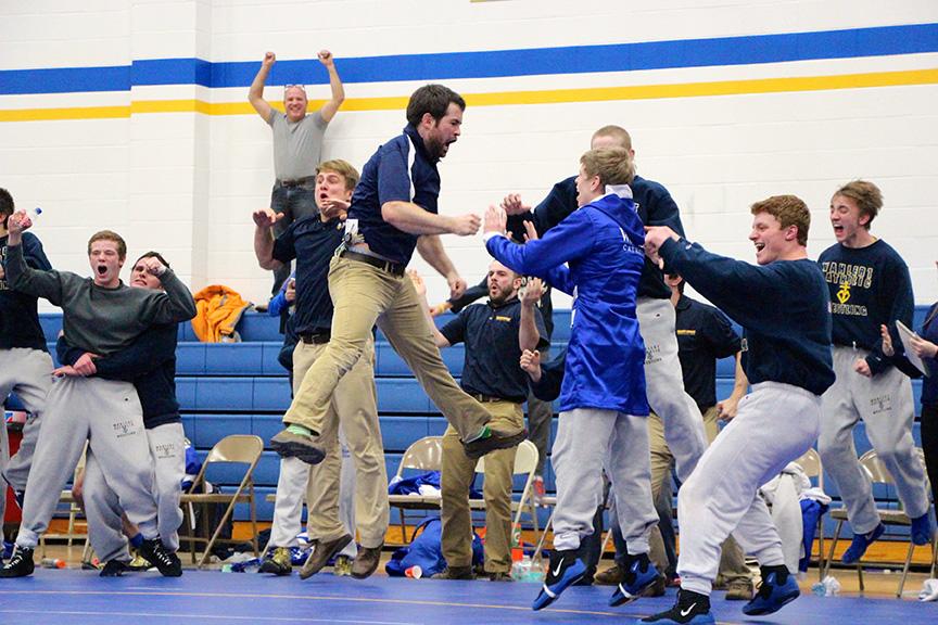 Wrestling Coach Joel Allen leaps into the air after freshman Blake Bradley pins his man and clinches the teams 35-32 win over Linn Mar.