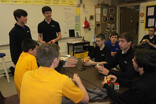 Rubix Cube Club leaders Alec Weber (left), and Guppy Berning (right), talk cubes with other club members.