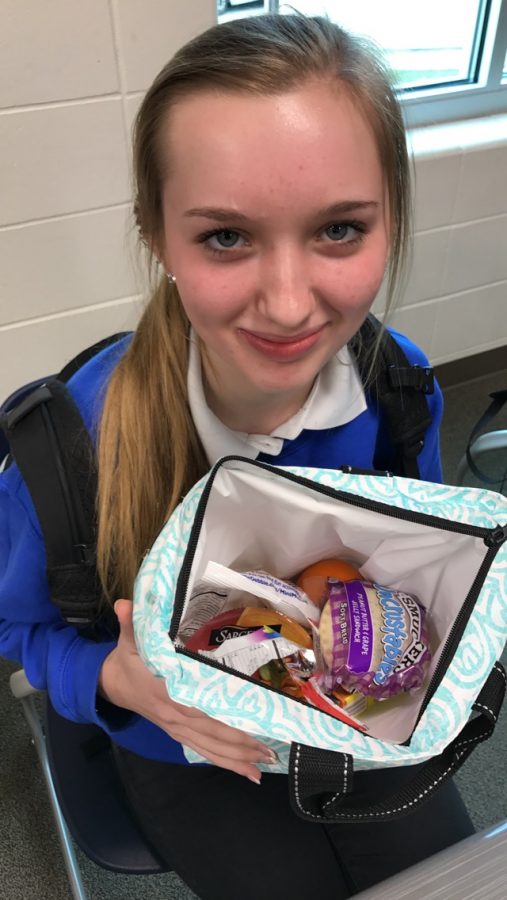 Alayna Chapman, 20, smiles with her lunchbox filled with her favorite foods.