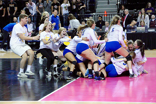 The volleyball team storms the court after winning the 4A state championship game. 
