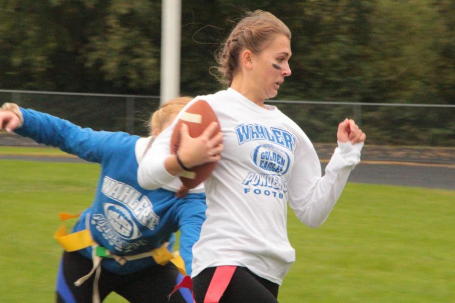 Olivia Blosch, 19, dodges a tackle by a junior to run the ball down the field to score during the homecoming powder puff football game. The seniors sealed the win with a score of 20-0. 