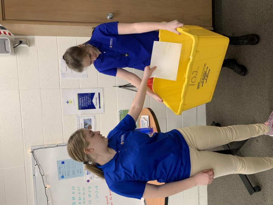 Veronica McDonald and Kylee Mitwede, 22, recycling in their classroom to prevent climate change.  