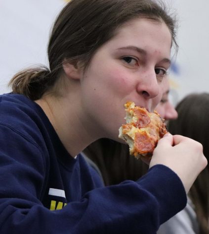 Lily Roth, 20, enjoys Happy Joes pizza while cheering on the boys basketball team. 
